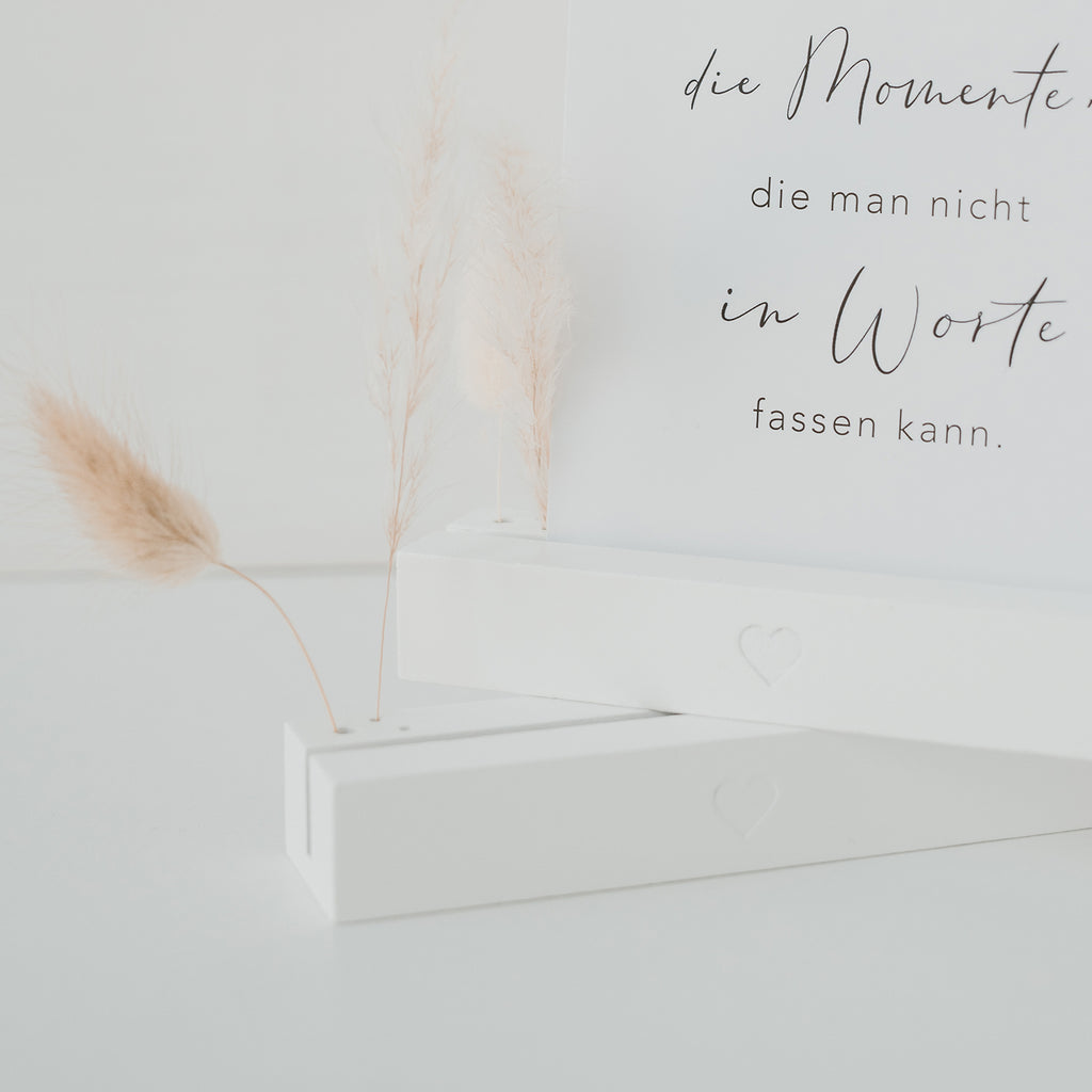 weißer Blumenständer mit Postkarte und Trockenblumen