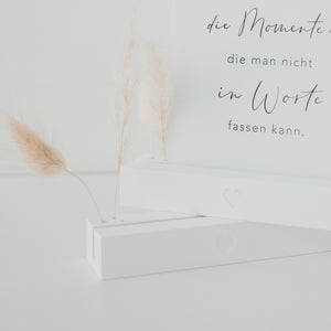 weißer Blumenständer mit Postkarte und Trockenblumen